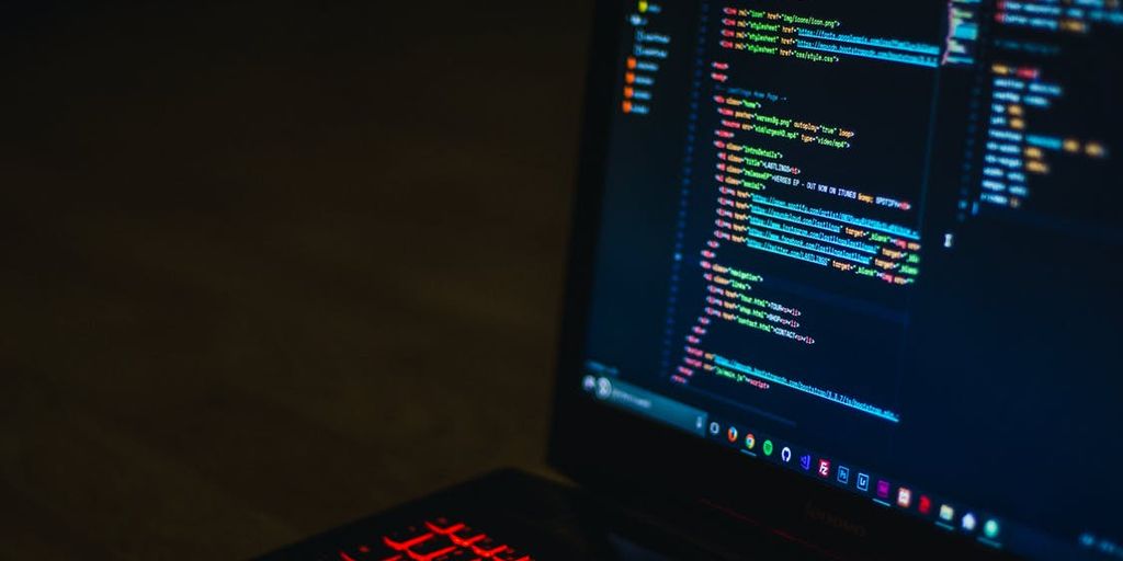 software testing team analyzing data on computer screens in modern office